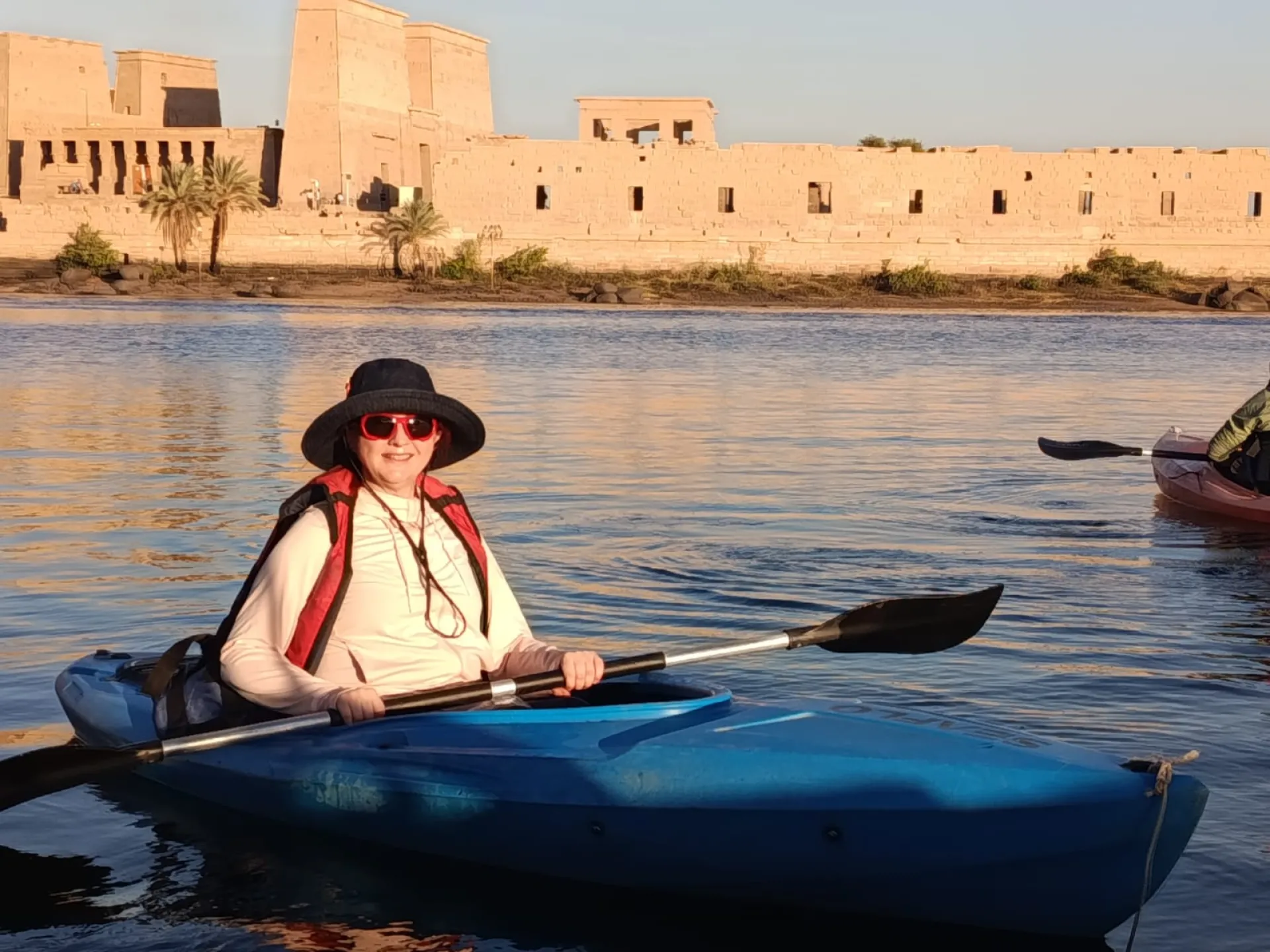 Tourist paddling a yellow kayak in the Nile River around