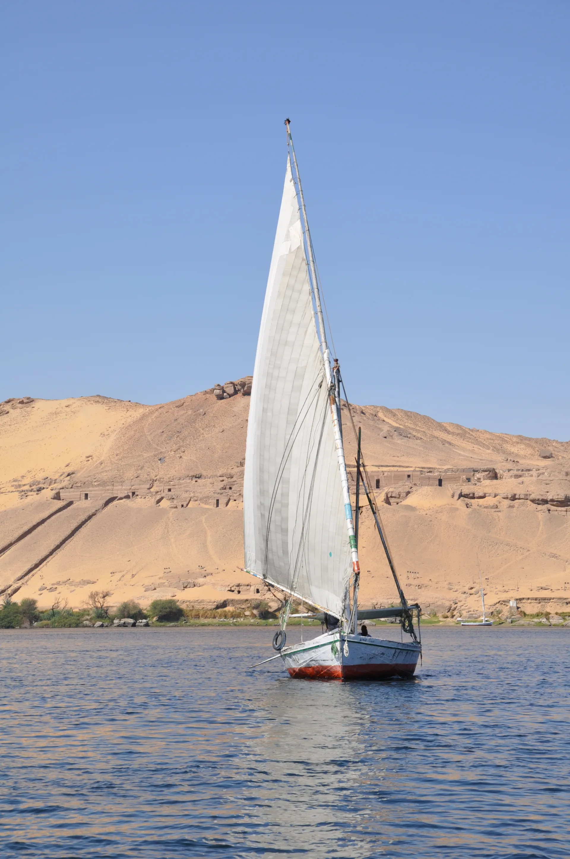 Private Felucca boat sailing on the Nile River in Aswan during a golden sunset